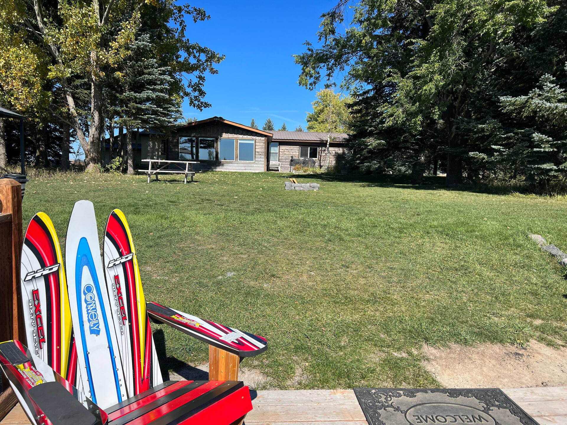Paddleboards and water skis by the fire pit chairs